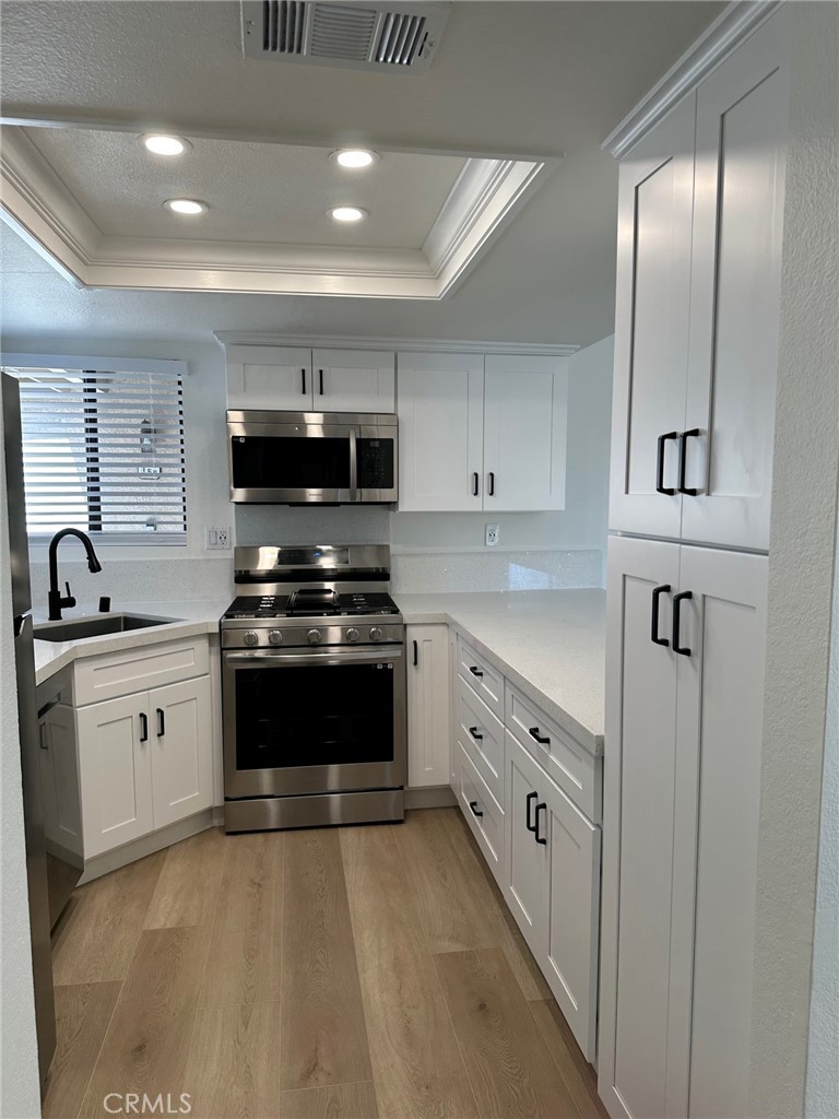 28142 Mariposa, Unit 154 Laguna Niguel, CA 92677 - Photo 8 of 35 a kitchen with granite countertop a stove sink and cabinets