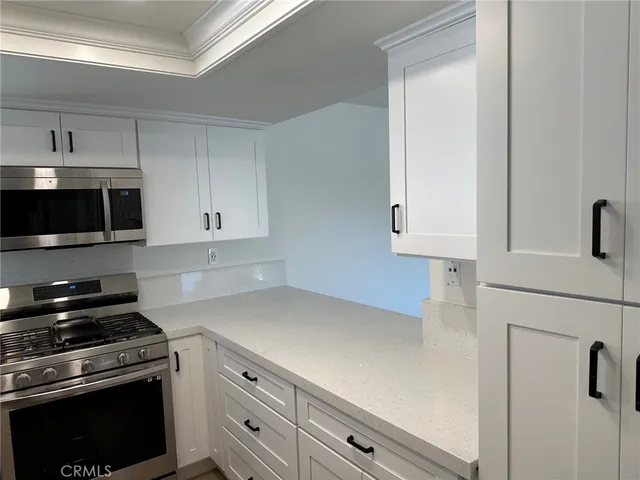 a kitchen with granite countertop a stove and a microwave