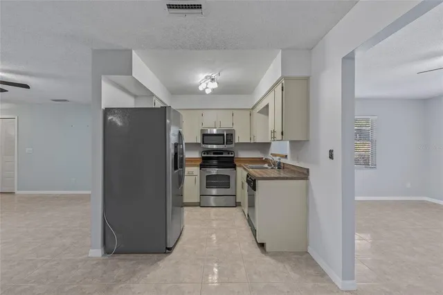 a kitchen with a refrigerator a stove top oven and a sink