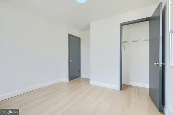 a spacious bedroom with a bed and a ceiling fan