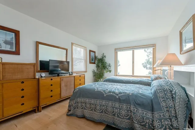 a bedroom with a large bed and a flat tv screen on dresser