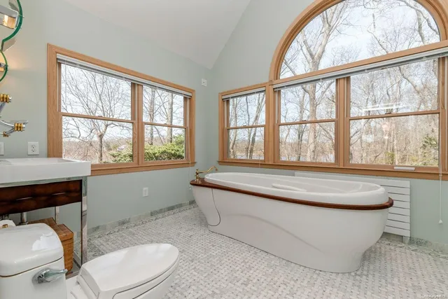 a bathroom with a toilet a sink and a window