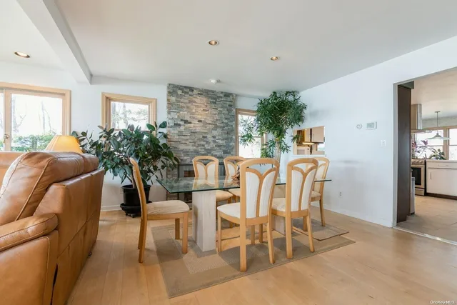 a dining room with furniture potted plants and wooden floor