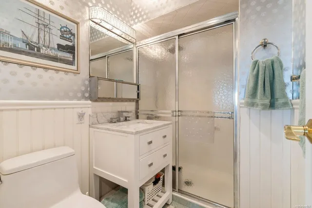 a bathroom with a granite countertop sink toilet and shower