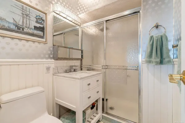 a bathroom with a granite countertop sink toilet and shower