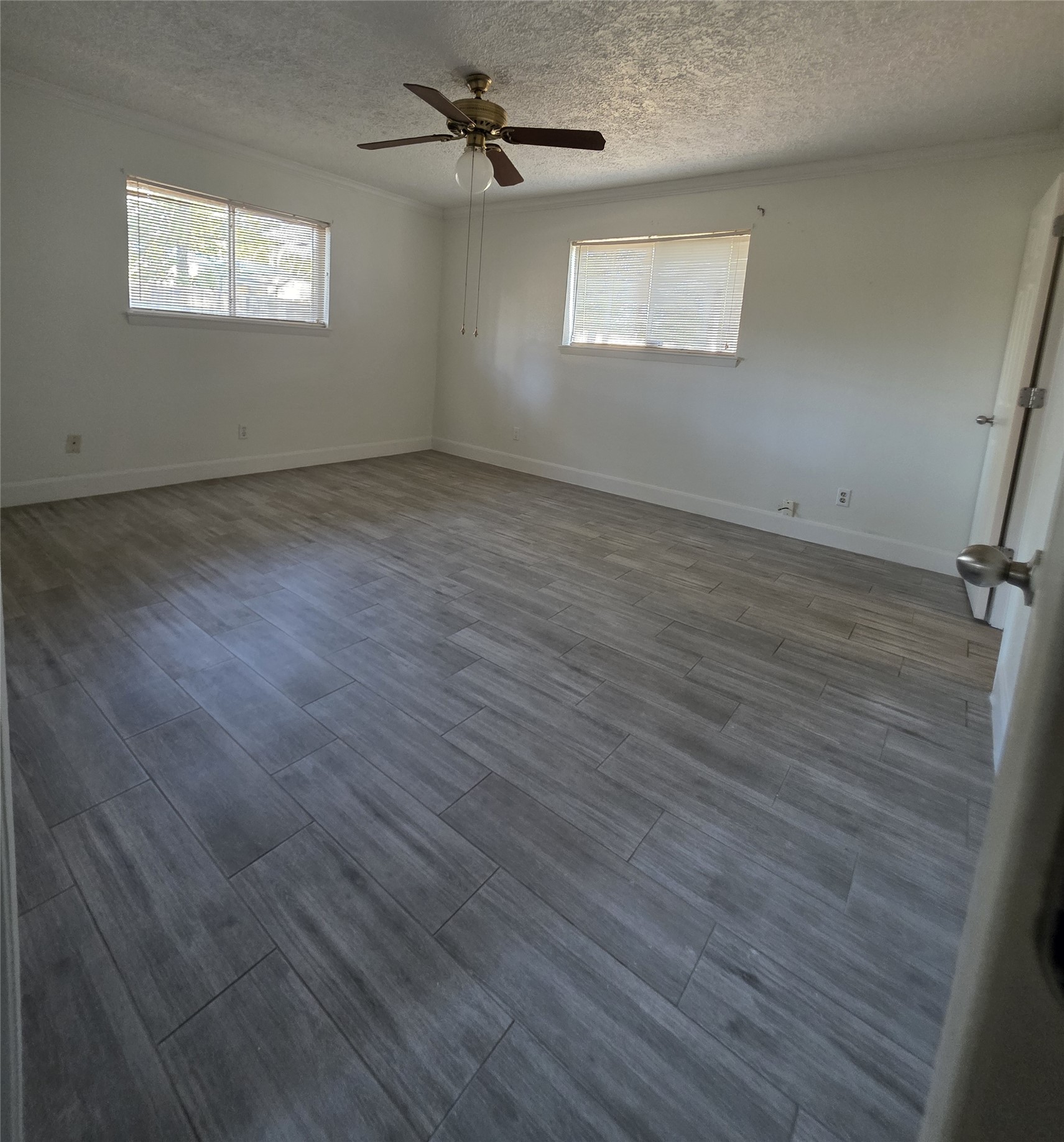 1819 Papoose Trail Crosby, TX 77532 - Photo 23 of 26 an empty room with wooden floor chandelier fan and windows