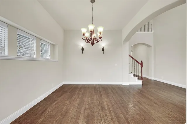 a view of a room with wooden floor and chandelier