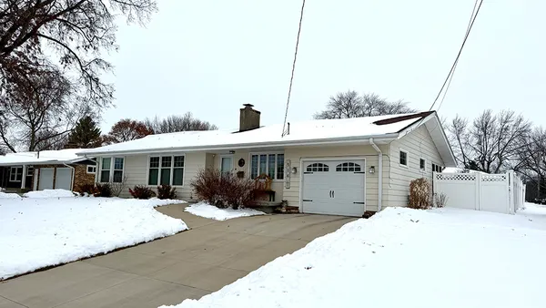 a front view of a house with a yard covered in snow