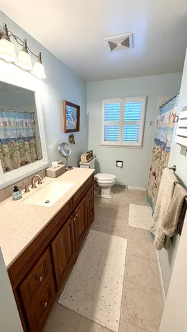 a bath room with a sink vanity and mirror