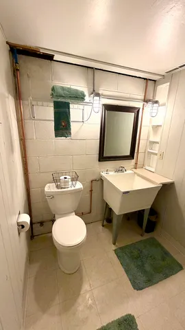 a bathroom with a toilet sink and mirror