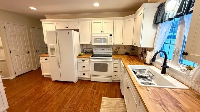 a kitchen with stainless steel appliances a stove a refrigerator and cabinets with wooden floor