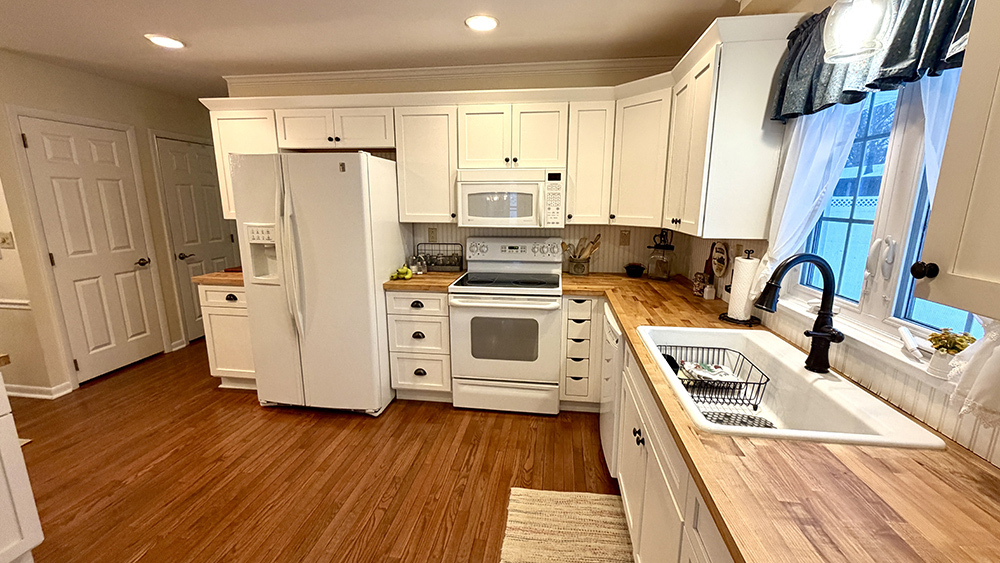 516 Christopher Street Morrison, IL 61270 - Photo 4 of 31 a kitchen with stainless steel appliances a stove a refrigerator and cabinets with wooden floor