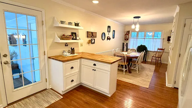 a kitchen with a dining table chairs and white appliances