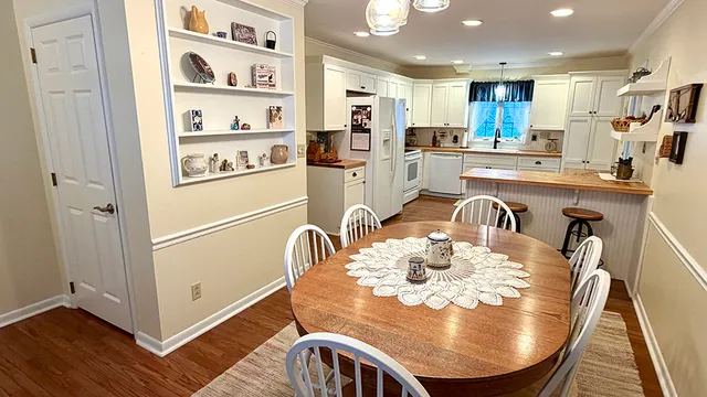 a view of a dining room with furniture a rug and wooden floor