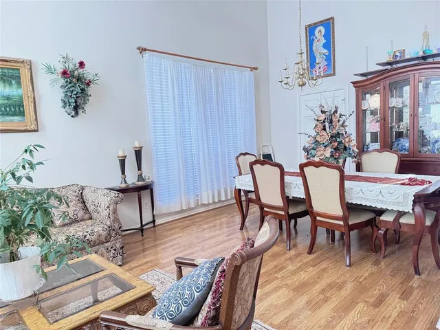 a dining room with furniture potted plants and wooden floor