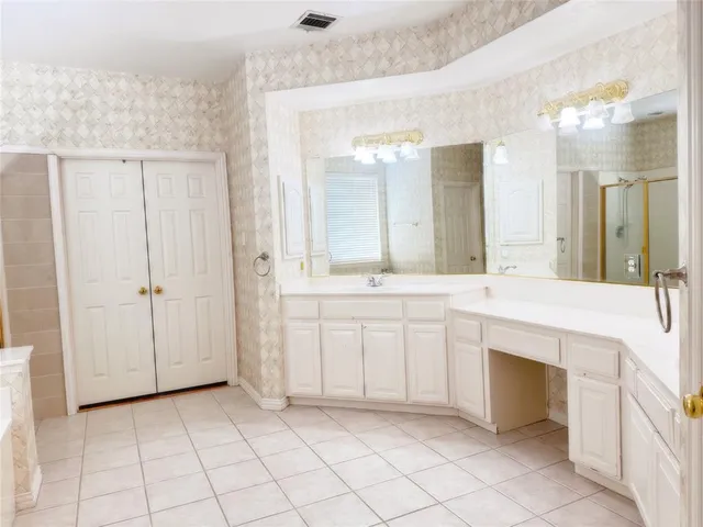 a spacious bathroom with a sink and a mirror