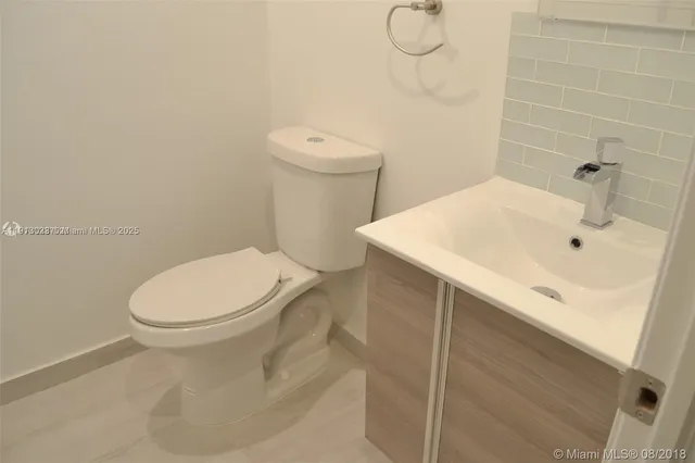 a bathroom with a sink toilet and mirror