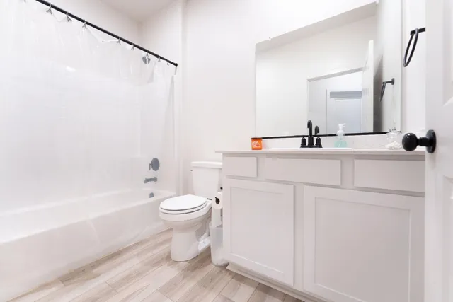 a bathroom with a sink a toilet and shower