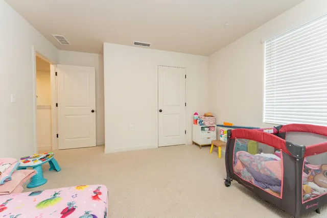 a bedroom with baby bed toys and a window