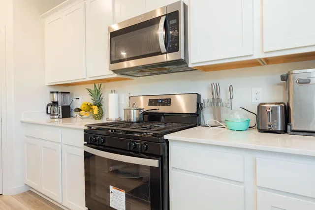 a kitchen with stainless steel appliances granite countertop a stove and a microwave