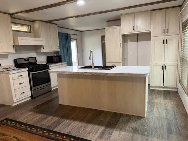 a kitchen with stainless steel appliances granite countertop a stove a refrigerator and a microwave