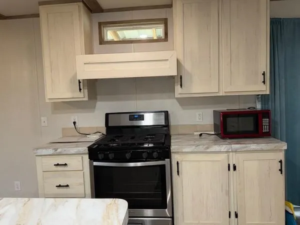 a kitchen with granite countertop white cabinets and appliances