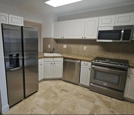 a kitchen with stainless steel appliances granite countertop a refrigerator stove and microwave