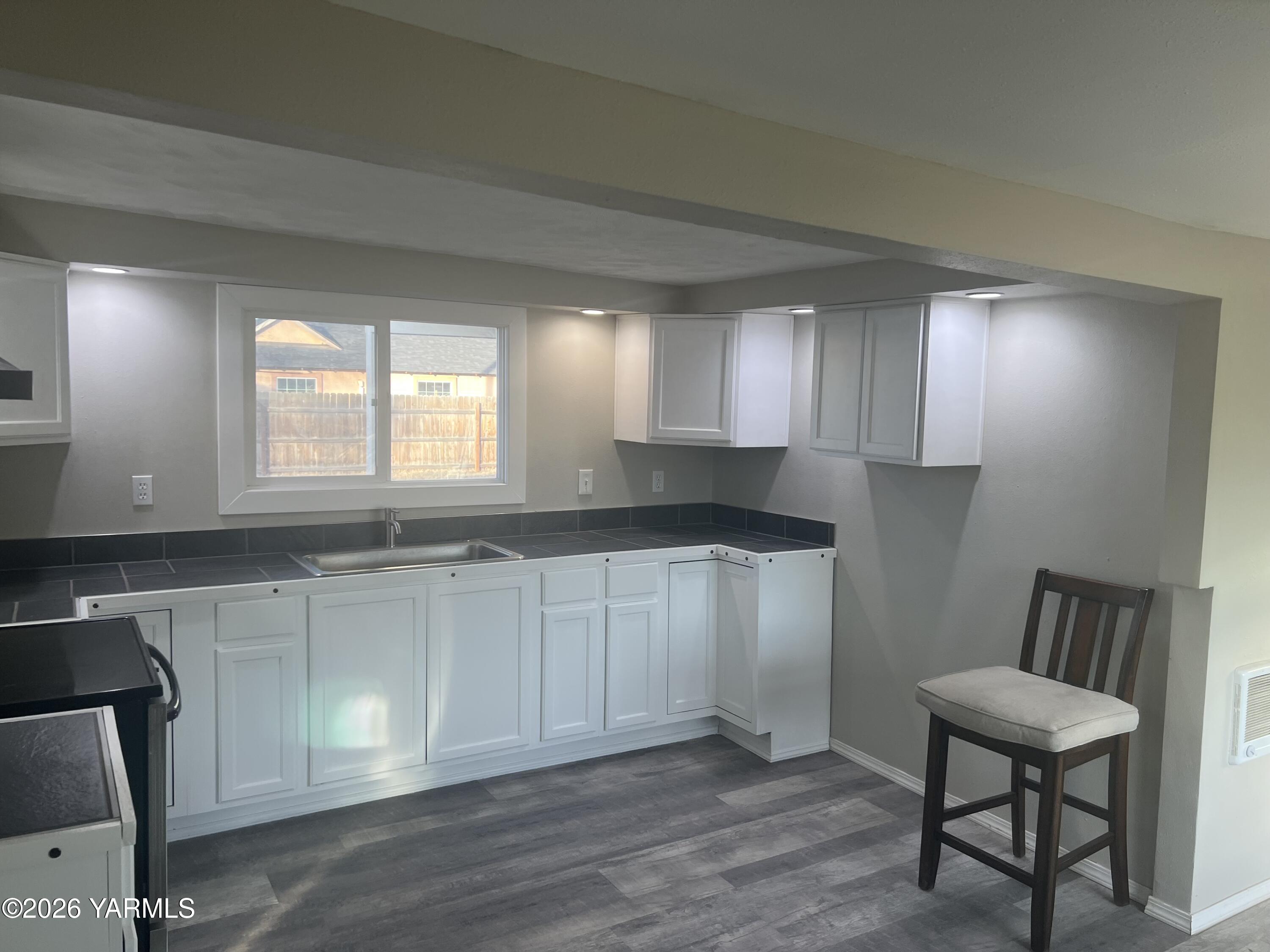 54704 North Evert Road Benton City, WA 99320 - Photo 20 of 21 a kitchen with granite countertop white cabinets a sink a window and stainless steel appliances