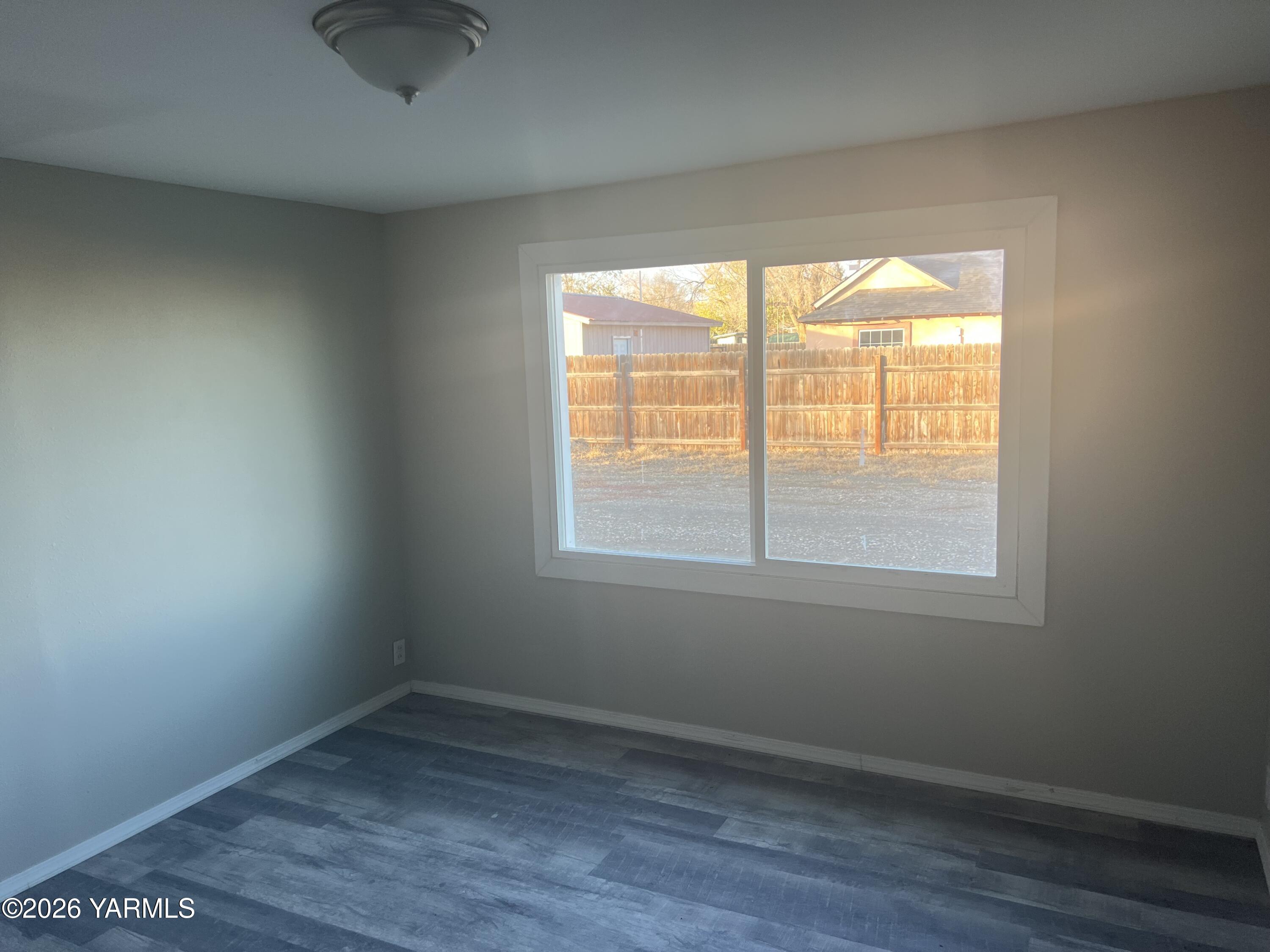 54704 North Evert Road Benton City, WA 99320 - Photo 4 of 21 an empty room with wooden floor and windows