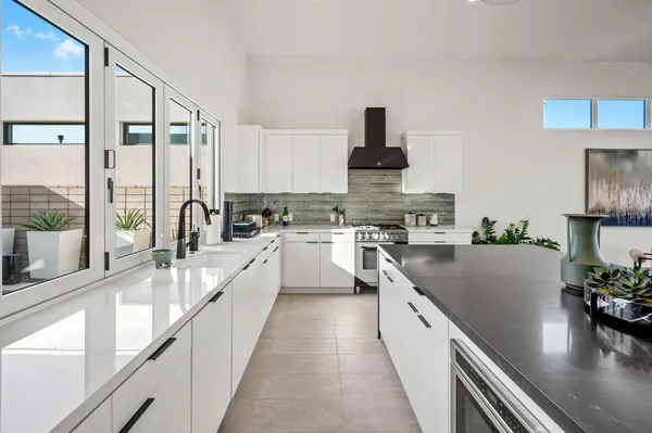 a large open kitchen with stainless steel appliances granite countertop a lot of counter space and a large window