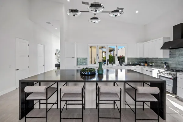 a kitchen with a dining table chairs stainless steel appliances and cabinets