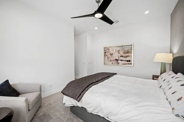 a bedroom with a bed and painting on the wall