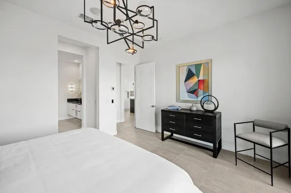 a bedroom with a bed and a chandelier