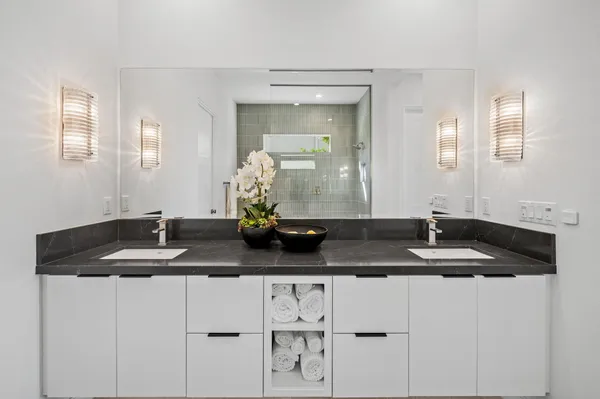 a bathroom with a granite countertop sink a mirror and vanity