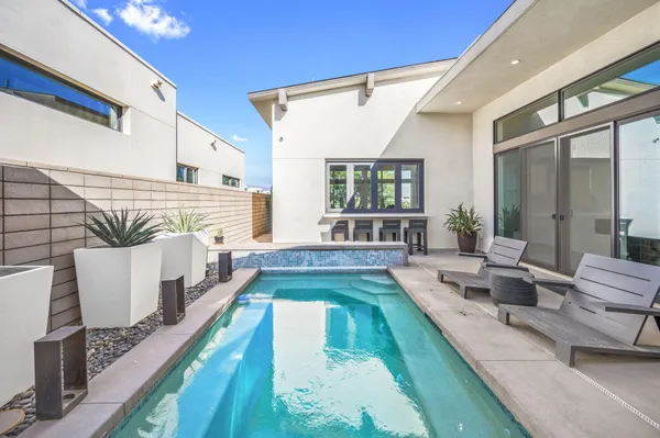 a large white bed sitting in a living room next to a large window