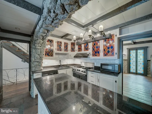 a view of an empty room with wooden floor and windows