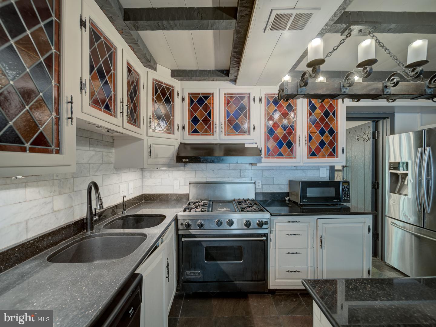 2142 Cathedral Avenue Northwest Washington, DC 20008 - Photo 31 of 60 a kitchen with stainless steel appliances granite countertop a sink stove and refrigerator