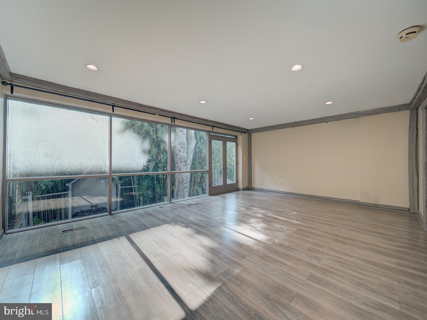 2142 Cathedral Avenue Northwest Washington, DC 20008 - Photo 44 of 60 a view of an empty room with wooden floor and a window
