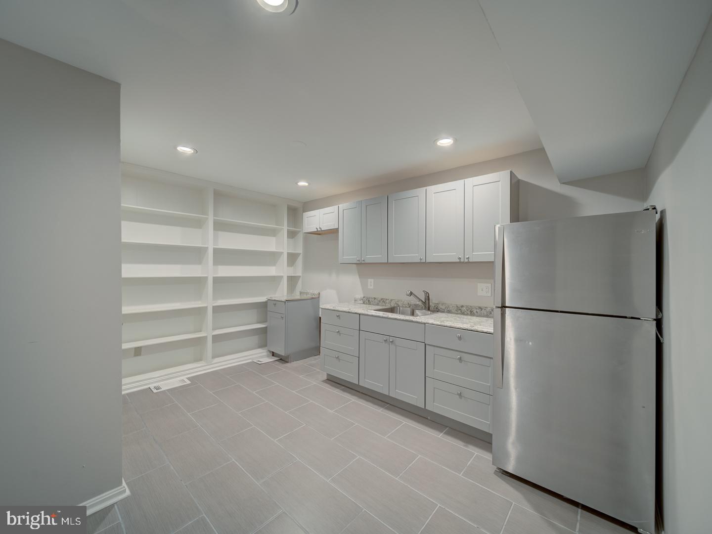 2142 Cathedral Avenue Northwest Washington, DC 20008 - Photo 56 of 60 a kitchen with white cabinets and refrigerator