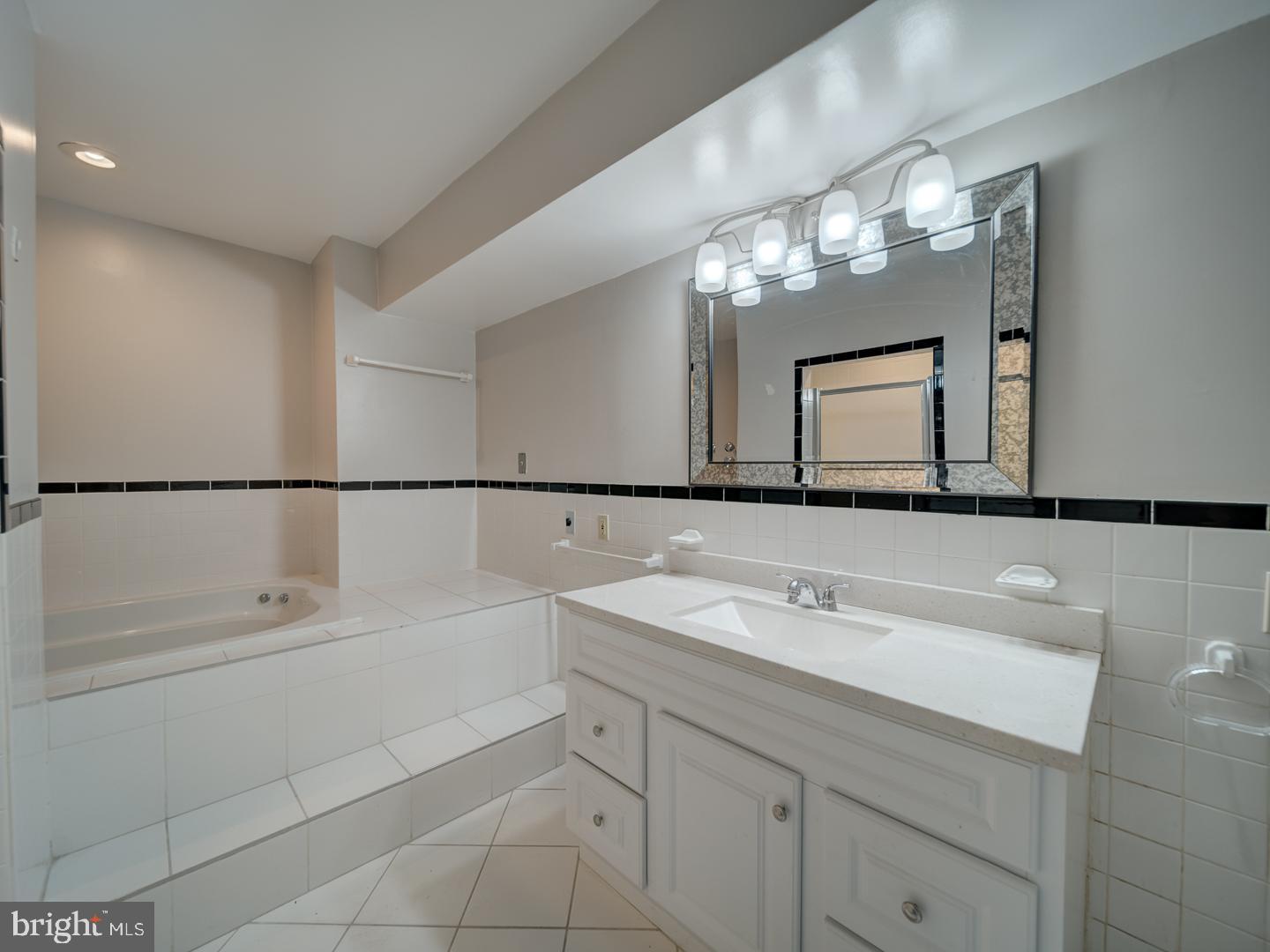 2142 Cathedral Avenue Northwest Washington, DC 20008 - Photo 58 of 60 a bathroom with a sink a tub and a mirror