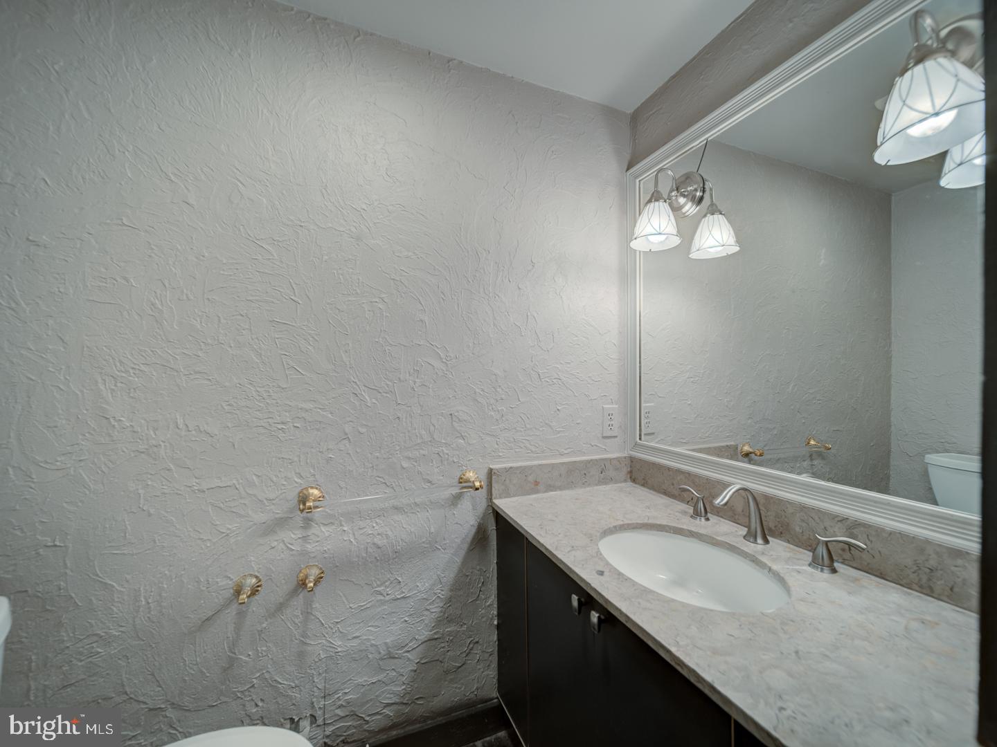 2142 Cathedral Avenue Northwest Washington, DC 20008 - Photo 10 of 60 a bathroom with a granite countertop sink and a mirror