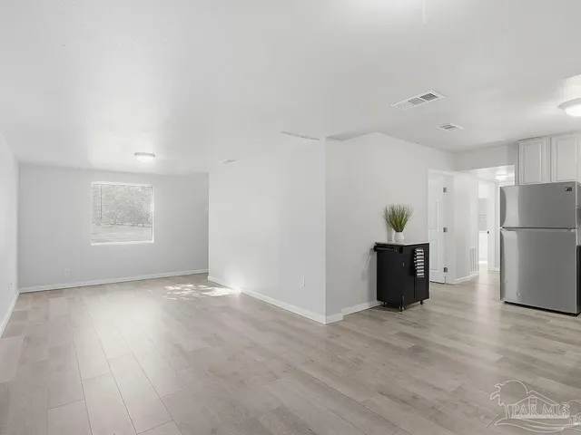 a view of a kitchen with a refrigerator and a wooden floor