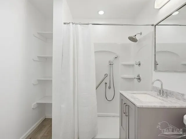 a bathroom with a shower sink and a mirror