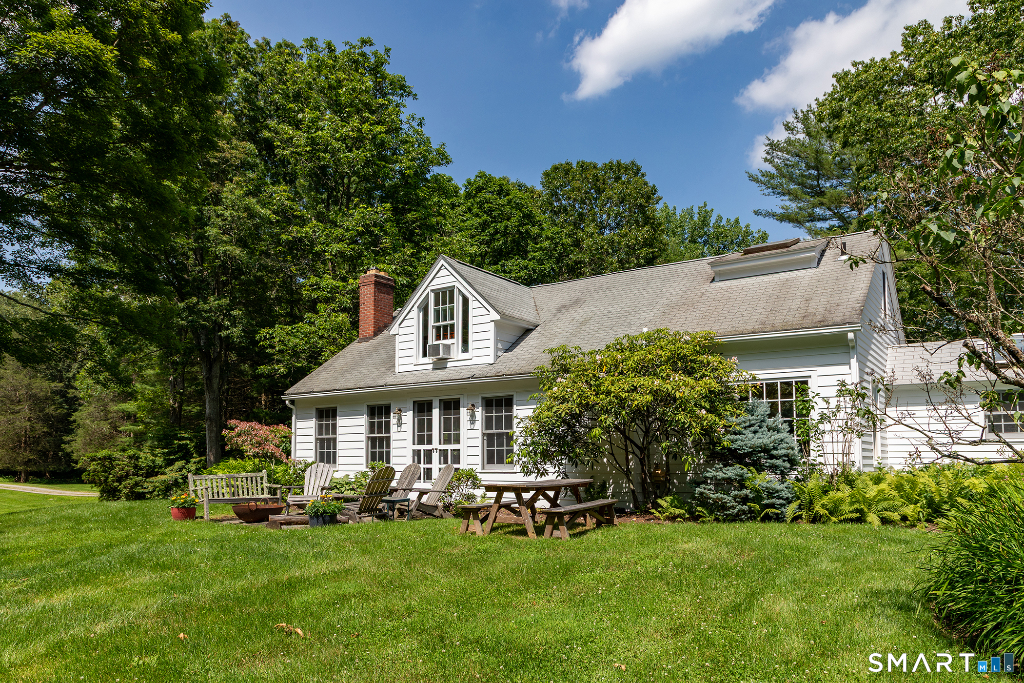 40 Camps Flat Road Kent, CT 06785 - Photo 3 of 5 a front view of a house with a yard table and chairs