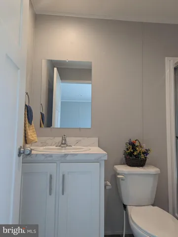 a bathroom with a granite countertop toilet sink and mirror