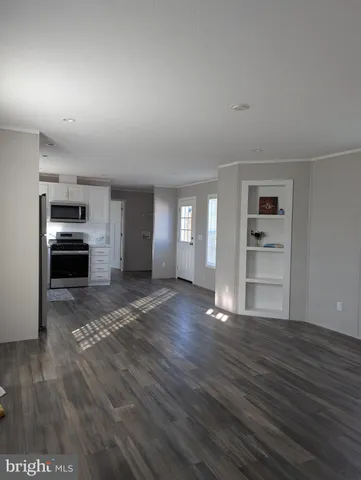 a view of empty room with kitchen and window