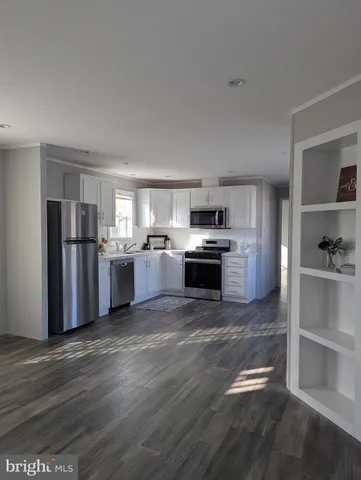 a kitchen with stainless steel appliances granite countertop a refrigerator stove and white cabinets