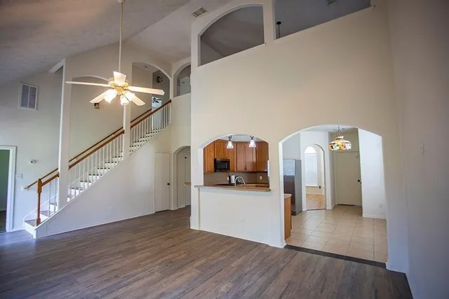 a view of a livingroom with wooden floor and staircase