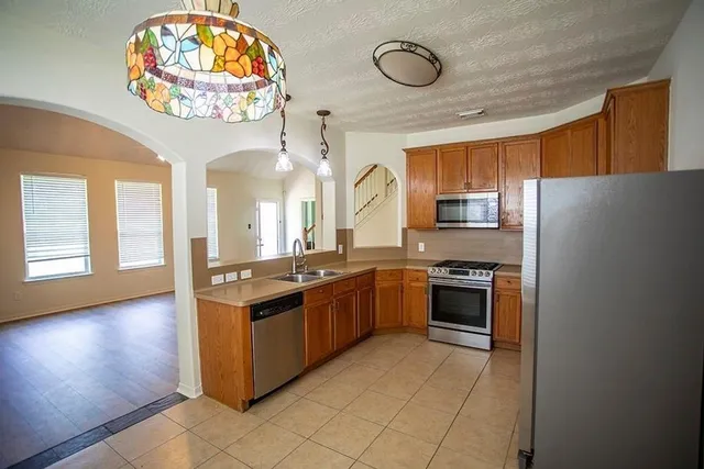 a large kitchen with stainless steel appliances granite countertop a stove and a refrigerator