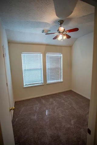 en empty room with windows and fan